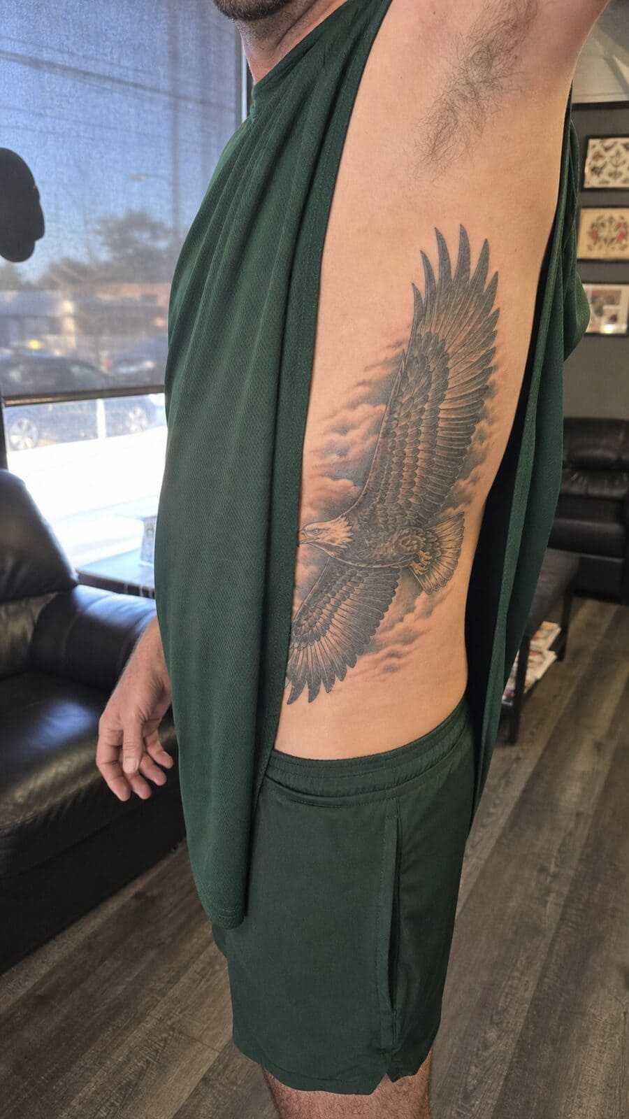 25 Rib Tattoos for Men Worth Considering 4 Healed majestic eagle tattoo on a adult man's side ribs, photographed in a natural relaxed documentary crop — study 1