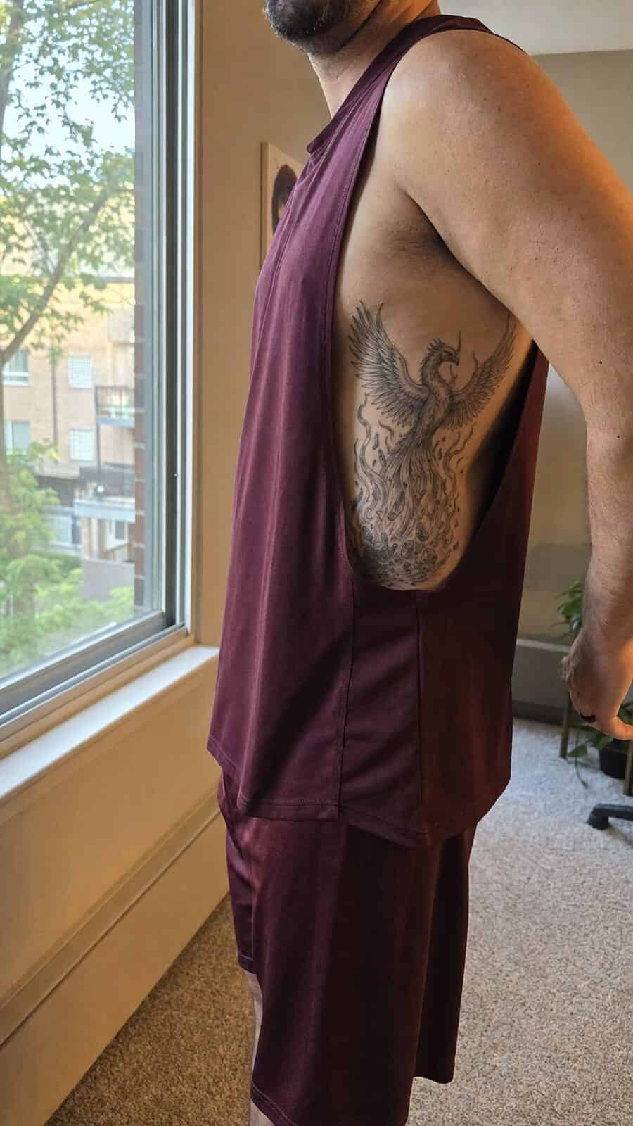 25 Rib Tattoos for Men Worth Considering 15 Healed phoenix rising tattoo on a adult man's side ribs, photographed in a natural straight-on close view, a touch off-center like a — study 3