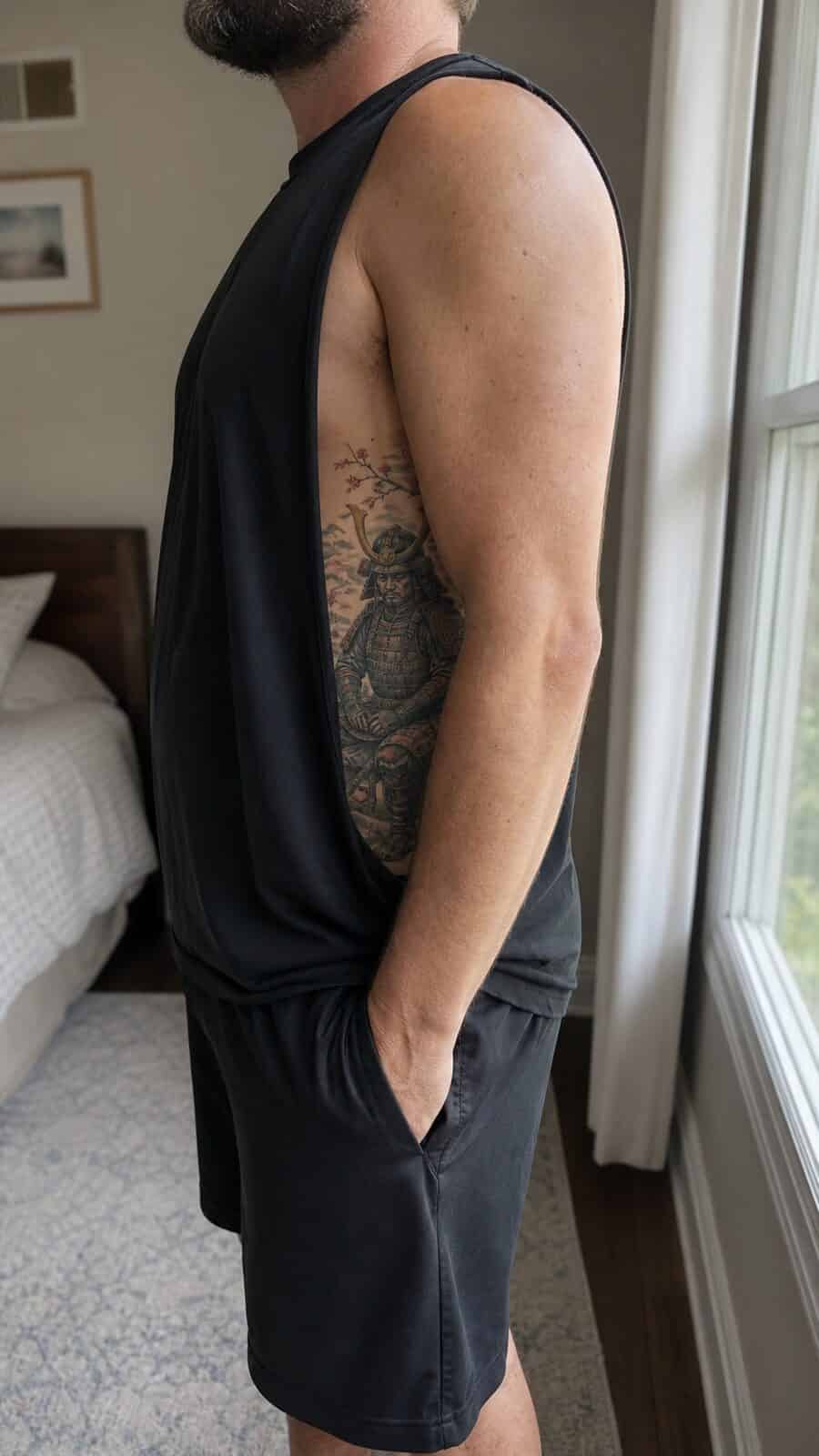 25 Rib Tattoos for Men Worth Considering 16 Healed samurai warrior tattoo on a adult man's side ribs, photographed in a natural gentle side angle that clearly shows how the ink — study 1