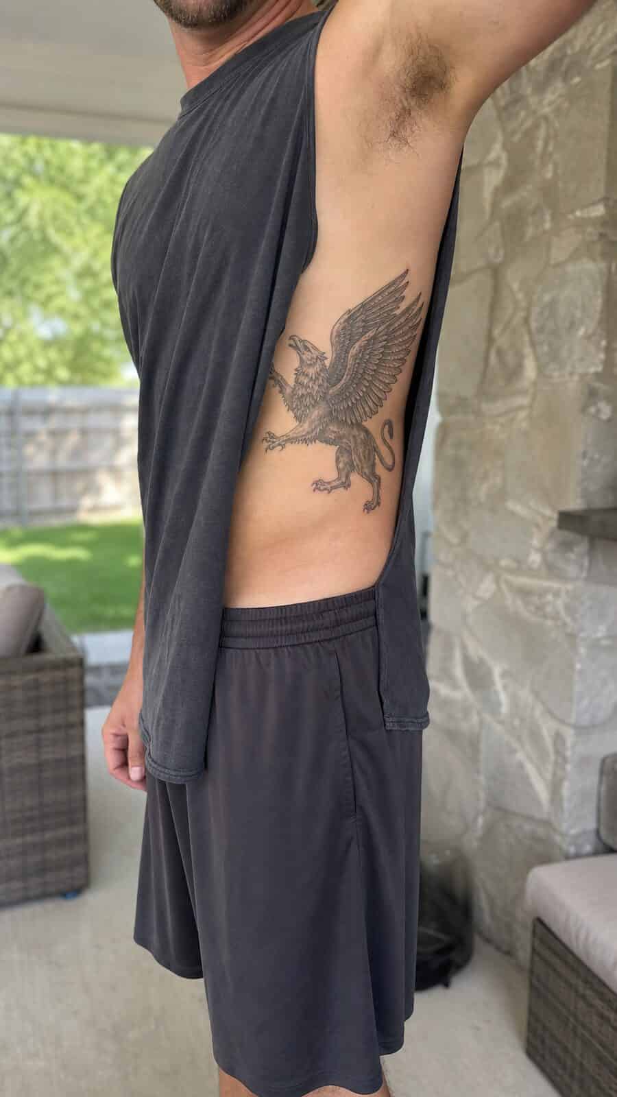 25 Rib Tattoos for Men Worth Considering 27 Healed mythical griffin tattoo on a adult man's side ribs, photographed in a natural gentle side angle that clearly shows how the ink — study 1