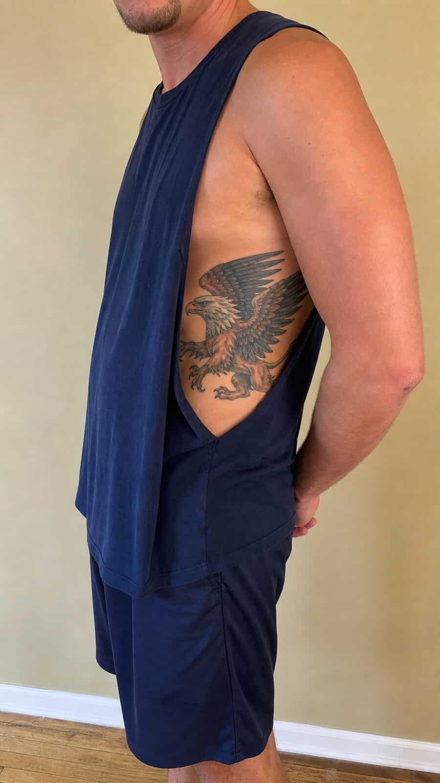 25 Rib Tattoos for Men Worth Considering 28 Healed mythical griffin tattoo on a adult man's side ribs, photographed in a natural slightly elevated close view — study 2