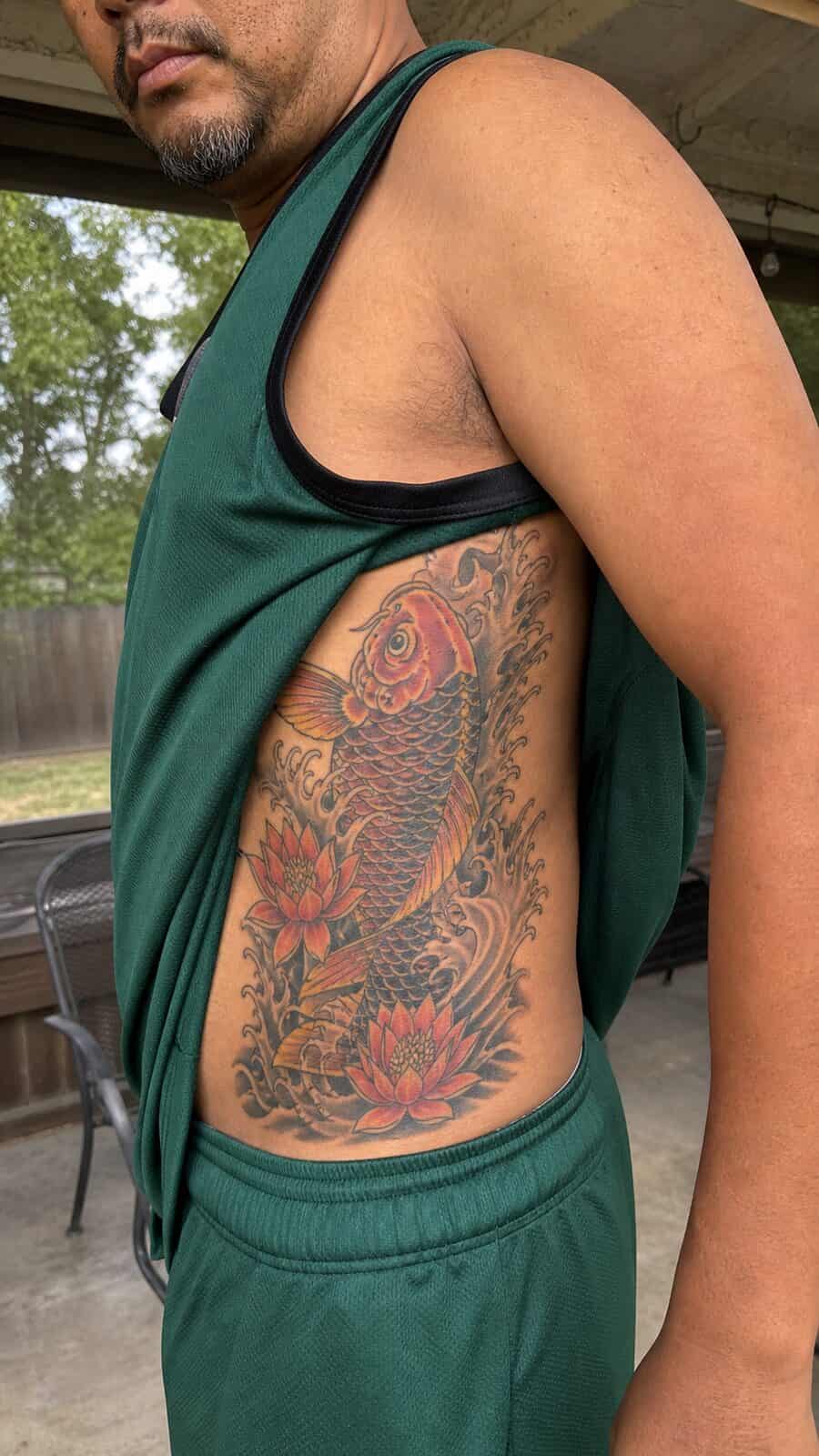 25 Rib Tattoos for Men Worth Considering 38 Healed japanese koi fish tattoo on a adult man's side ribs, photographed in a natural straight-on close view, a touch off-center like — study 1