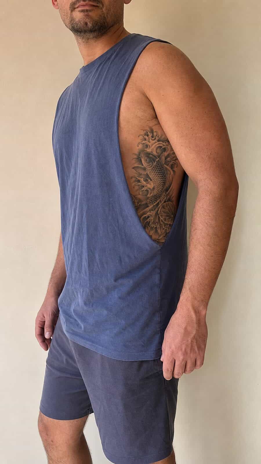 25 Rib Tattoos for Men Worth Considering 39 Healed japanese koi fish tattoo on a adult man's side ribs, photographed in a natural gentle side angle that clearly shows how the ink — study 2