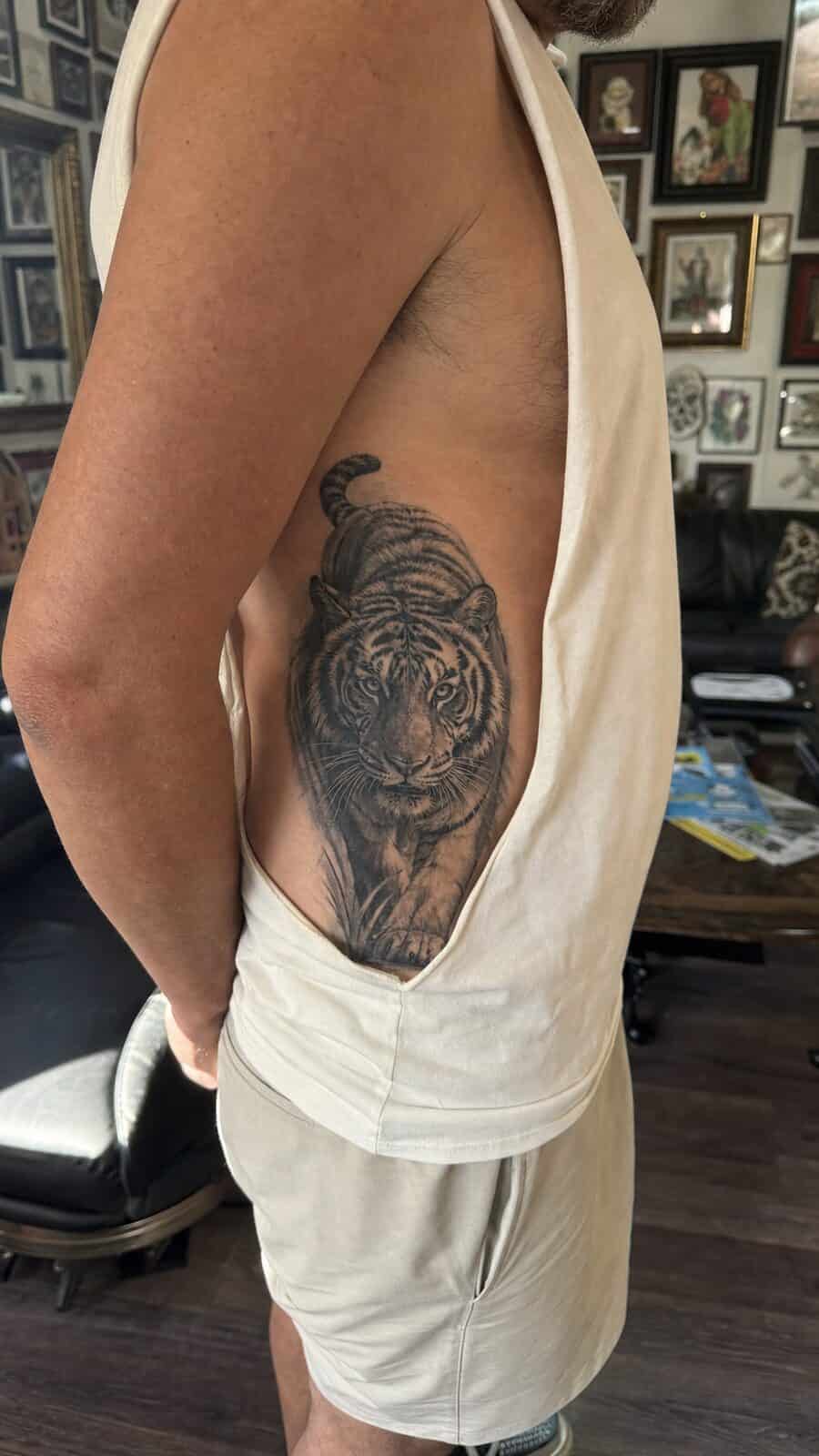 25 Rib Tattoos for Men Worth Considering 42 Healed realistic tiger tattoo on a adult man's side ribs, photographed in a natural straight-on close view, a touch off-center like a — study 1