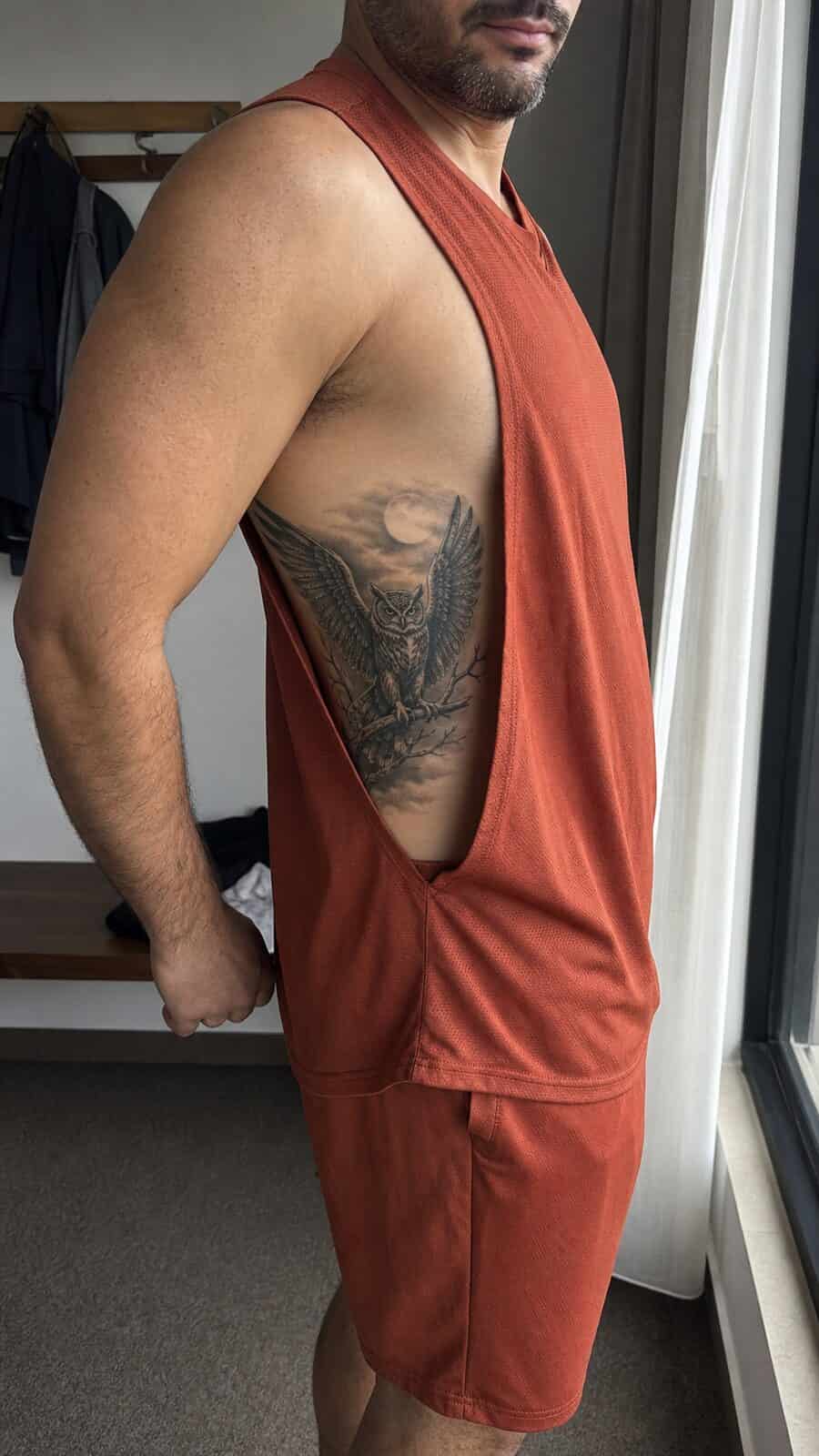 25 Rib Tattoos for Men Worth Considering 45 Healed mystical owl tattoo on a adult man's side ribs, photographed in a natural slightly elevated close view — study 1