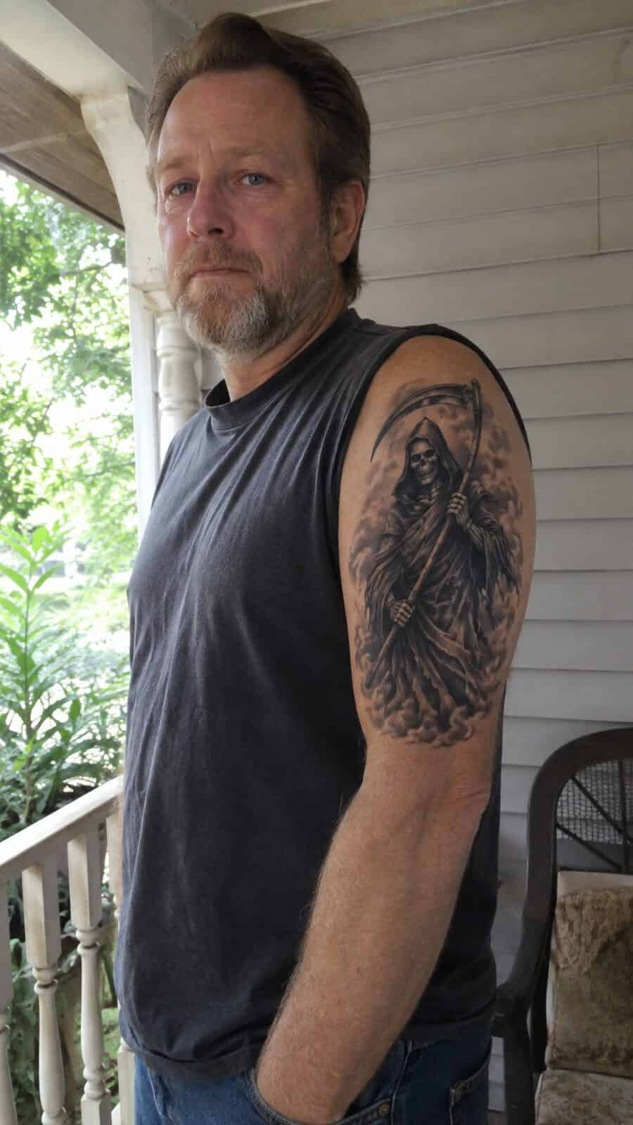 Unlock Your Next Ink: 25 Epic Upper Arm Tattoo Ideas for Men 56 Healed grim reaper with scythe tattoo on a adult man's outer upper arm, photographed in a natural slightly elevated close view — study 3