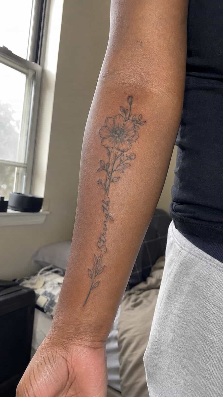 35 Forearm Tattoos for Women Worth Considering 3 Healed blossom of strength tattoo on a adult woman's inner forearm, photographed in a natural relaxed documentary crop — study 2