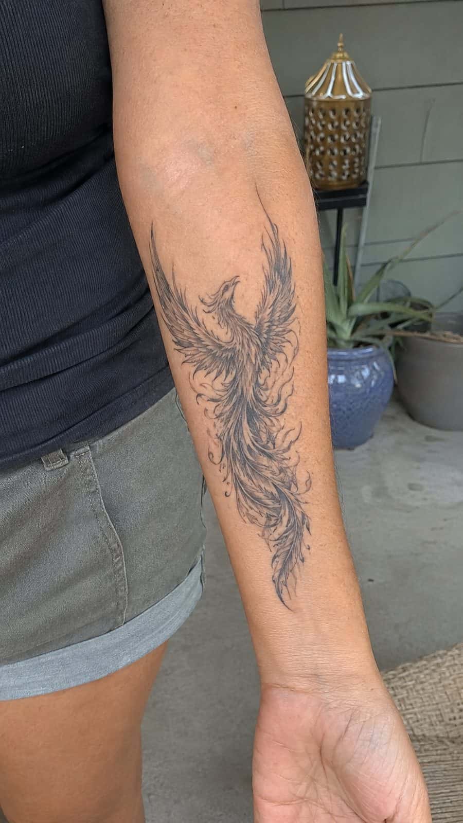 35 Forearm Tattoos for Women Worth Considering 7 Healed rising phoenix tattoo on a adult woman's inner forearm, photographed in a natural waist-height candid close-up — study 3