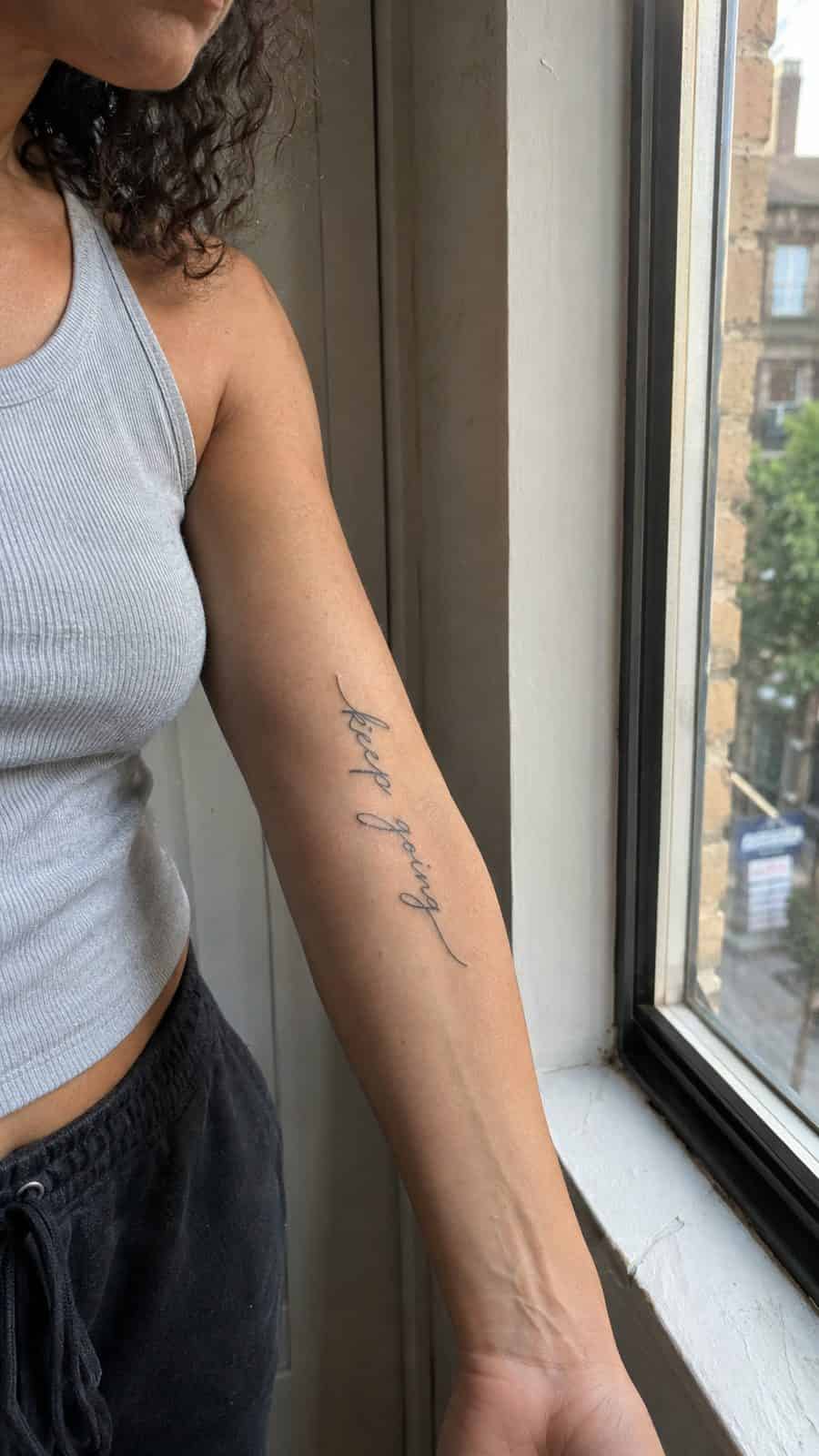 35 Forearm Tattoos for Women Worth Considering 16 Healed flowing script tattoo on a adult woman's inner forearm, photographed in a natural casual close three-quarter view — study 1