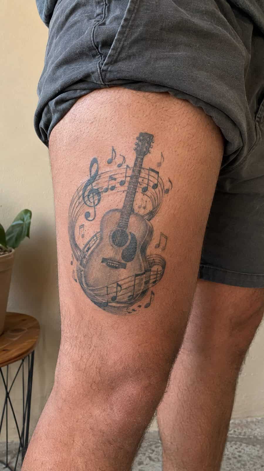 48 Tattoo Ideas for Men Worth Considering for Your Next Ink 13 Healed harmonious tunes tattoo on a adult man's outer thigh, photographed in a natural waist-height candid close-up — study 1