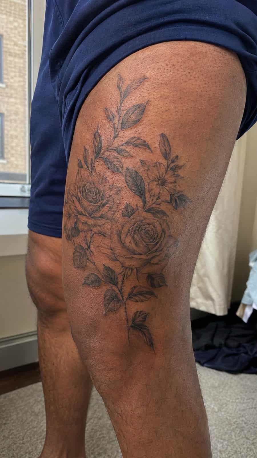 48 Tattoo Ideas for Men Worth Considering for Your Next Ink 24 Healed floral elegance tattoo on a adult man's outer thigh, photographed in a natural casual close three-quarter view — study 1