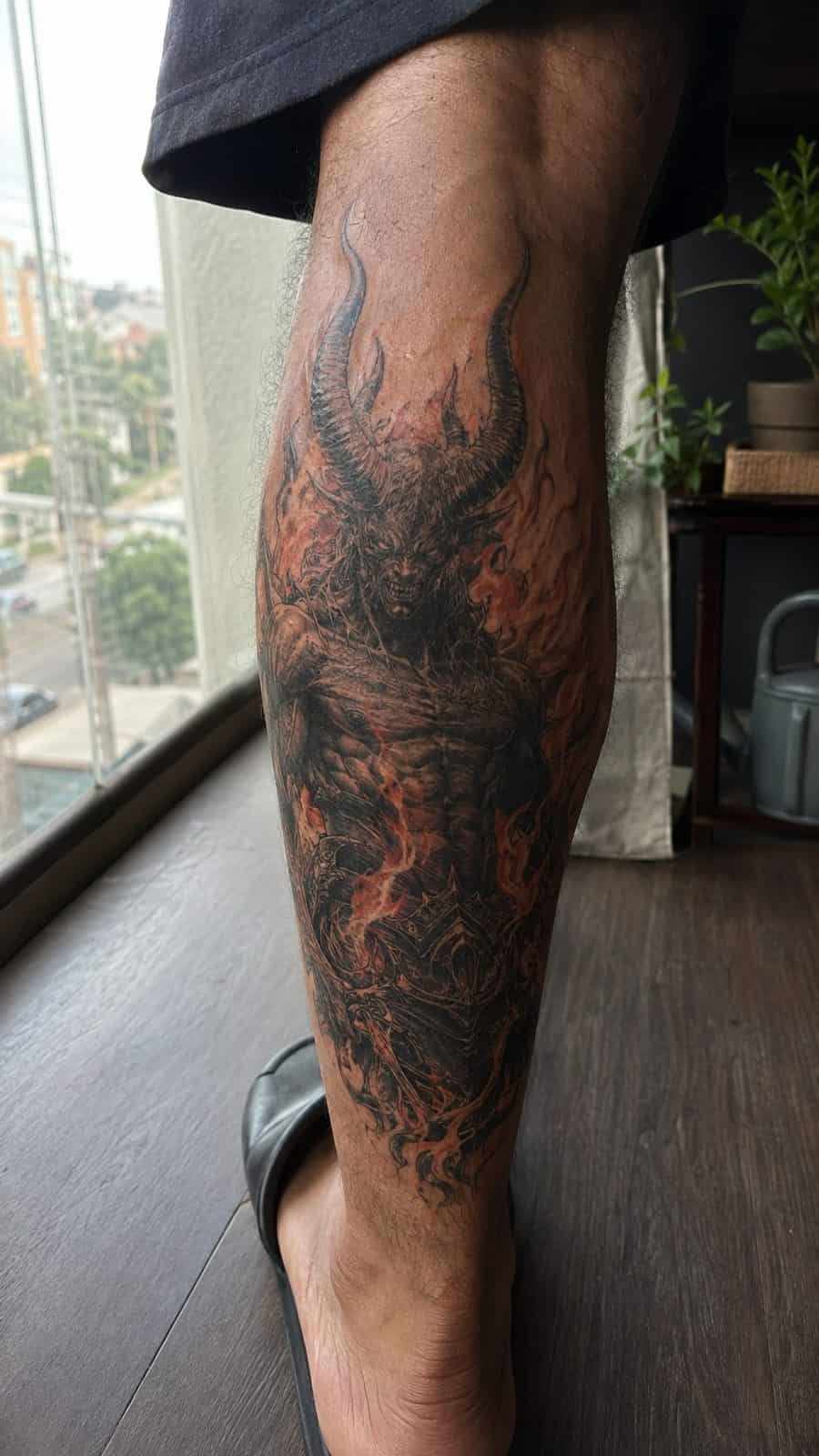 Unleash Your Dark Side: 23 Devilishly Unique Tattoo Ideas for Men 3 Healed fiery horned demon tattoo on a adult man's outer calf, photographed in a natural relaxed documentary crop — study 2