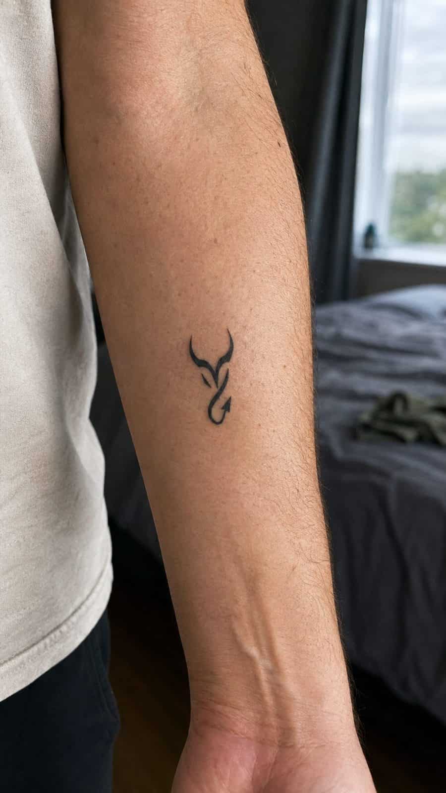 Unleash Your Dark Side: 23 Devilishly Unique Tattoo Ideas for Men 29 Healed minimalist devil symbol tattoo on a adult man's inner forearm, photographed in a natural straight-on close view, a touch — study 2