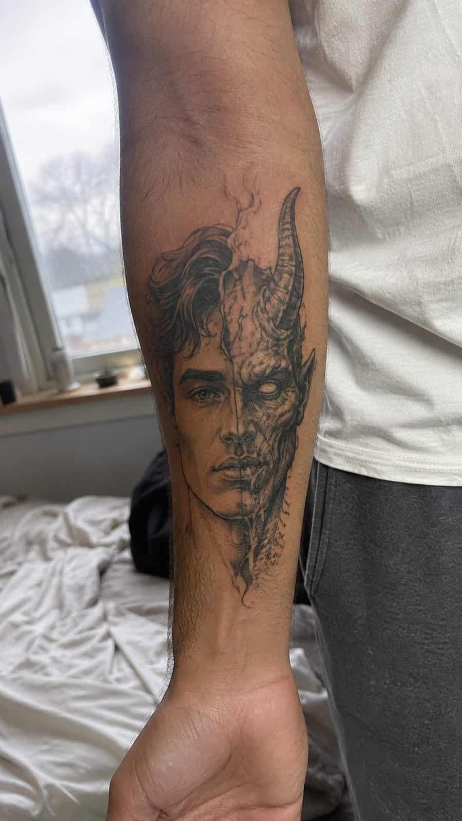 Unleash Your Dark Side: 23 Devilishly Unique Tattoo Ideas for Men 49 Healed devil-morphed portrait tattoo on a adult man's inner forearm, photographed in a natural waist-height candid close-up — study 2