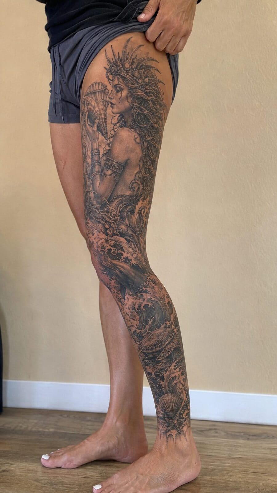 32 Gorgeous Female Leg Sleeve Tattoos 6 Healed goddess of the sea tattoo on a adult woman's full outer leg sleeve, photographed in a natural relaxed documentary crop — study 2