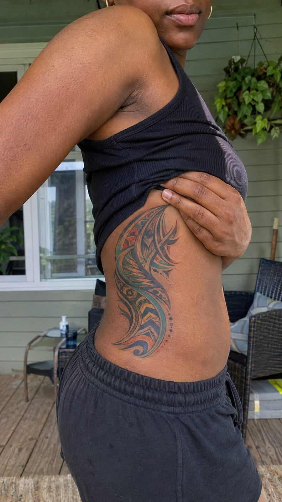 32 Gorgeous Female Leg Sleeve Tattoos 35 Healed vibrant tribal fusion tattoo on a adult woman's side ribs, photographed in a natural waist-height candid close-up — study 2