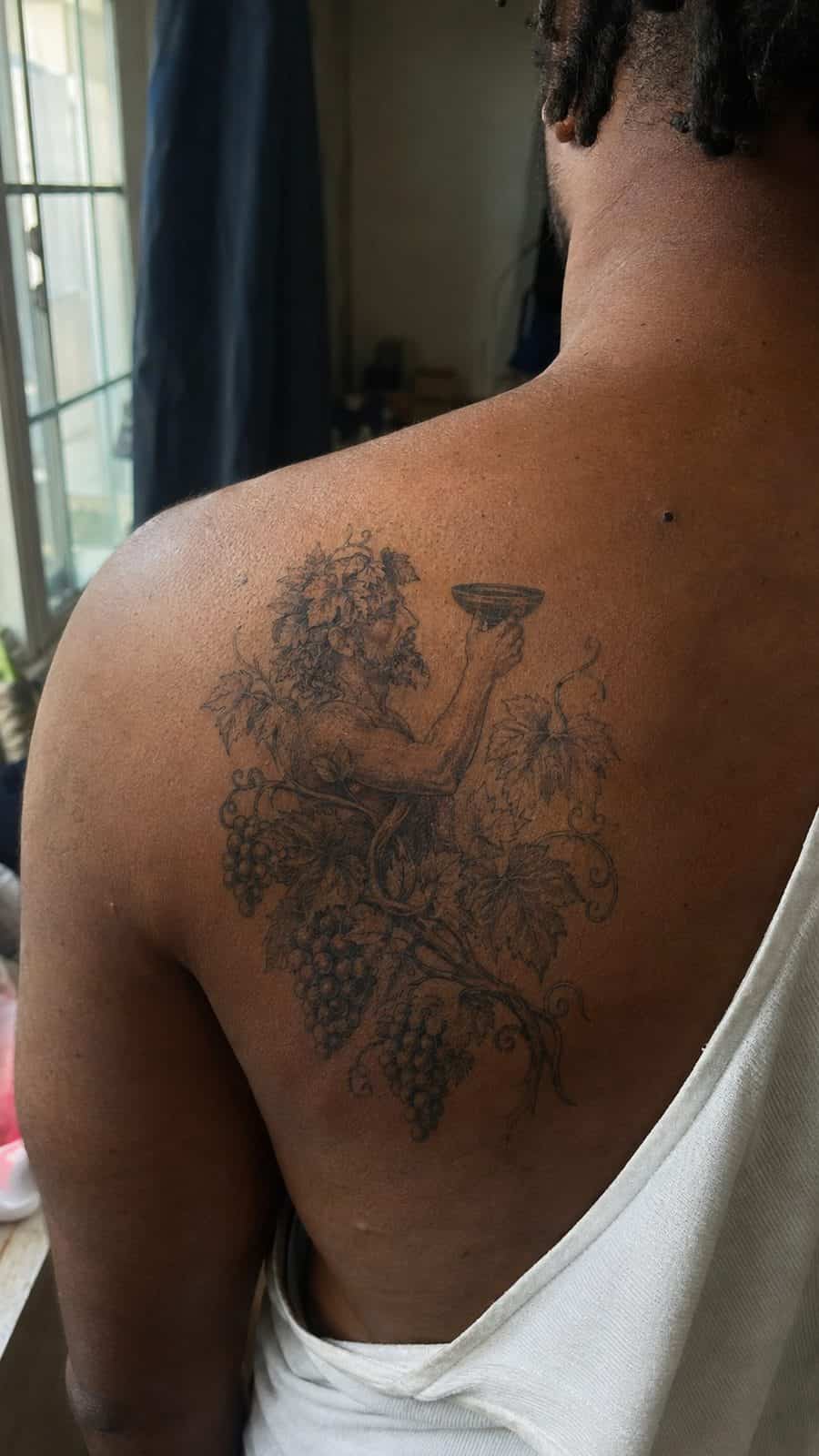 Modern Spartan: 18 Greek Tattoo Ideas Every Man Should Consider 33 Healed dionysus's grapevine tattoo on a adult man's upper back, photographed in a natural slightly elevated close view — study 1