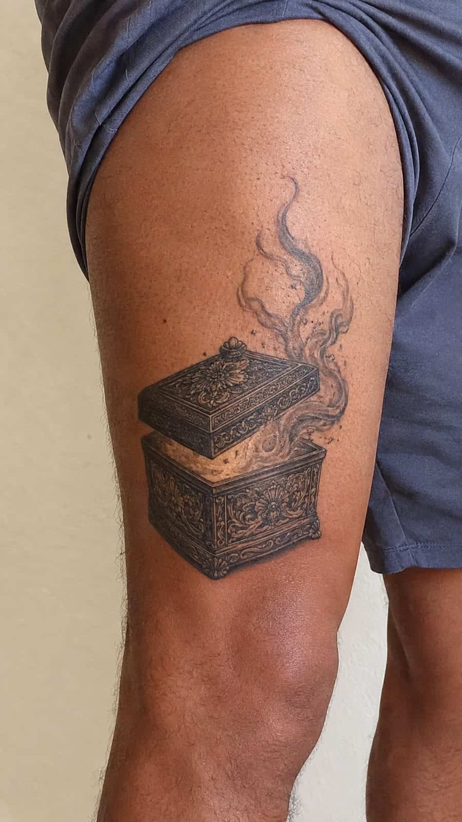 Modern Spartan: 18 Greek Tattoo Ideas Every Man Should Consider 44 Healed pandora's box tattoo on a adult man's outer thigh, photographed in a natural casual close three-quarter view — study 2