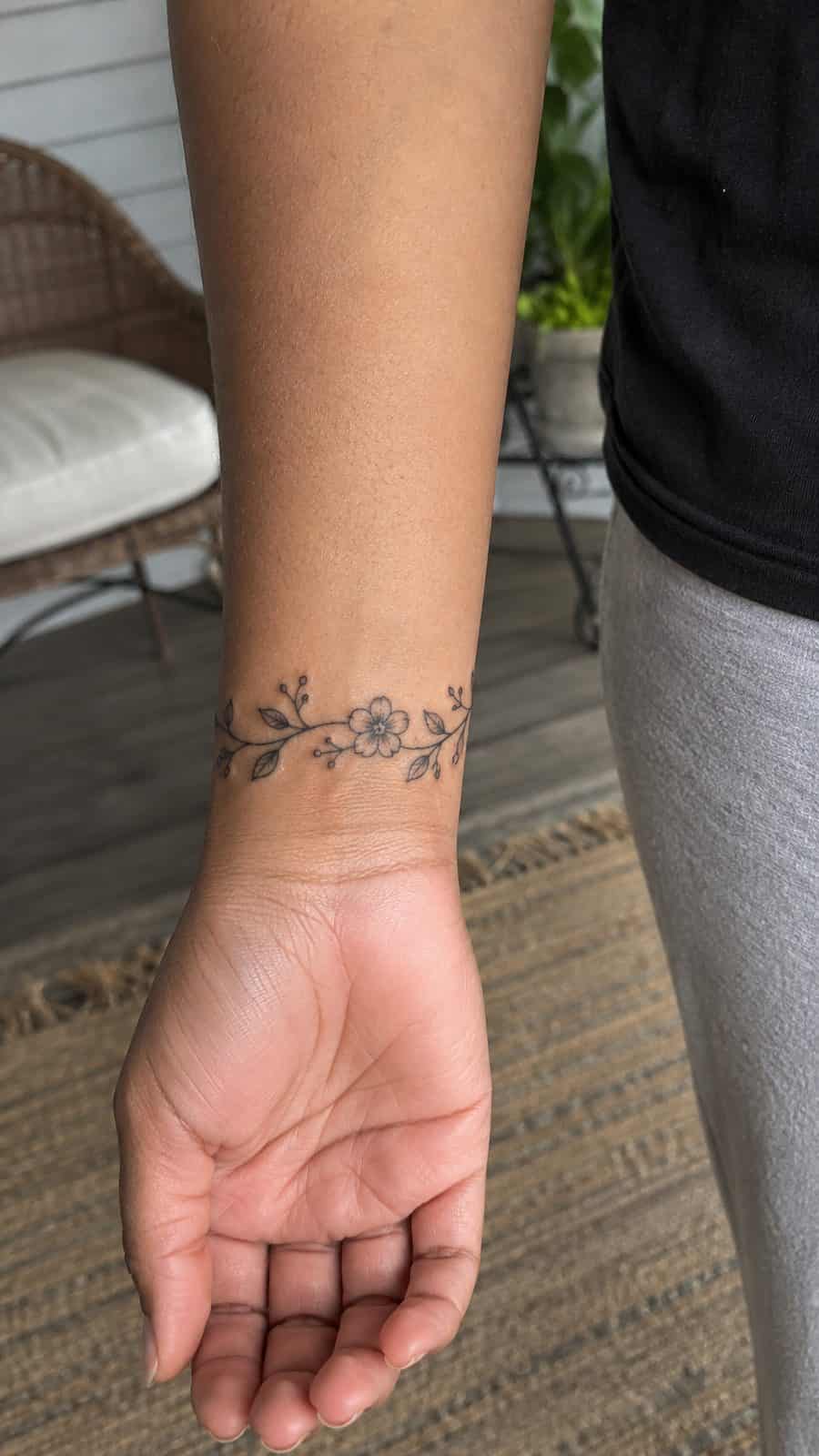 Wrist Tattoos Women Are Raving About: Discover the 28 Most Gorgeous Designs 2 Healed delicate floral vine tattoo on a adult woman's inner wrist, photographed in a natural waist-height candid close-up — study 1