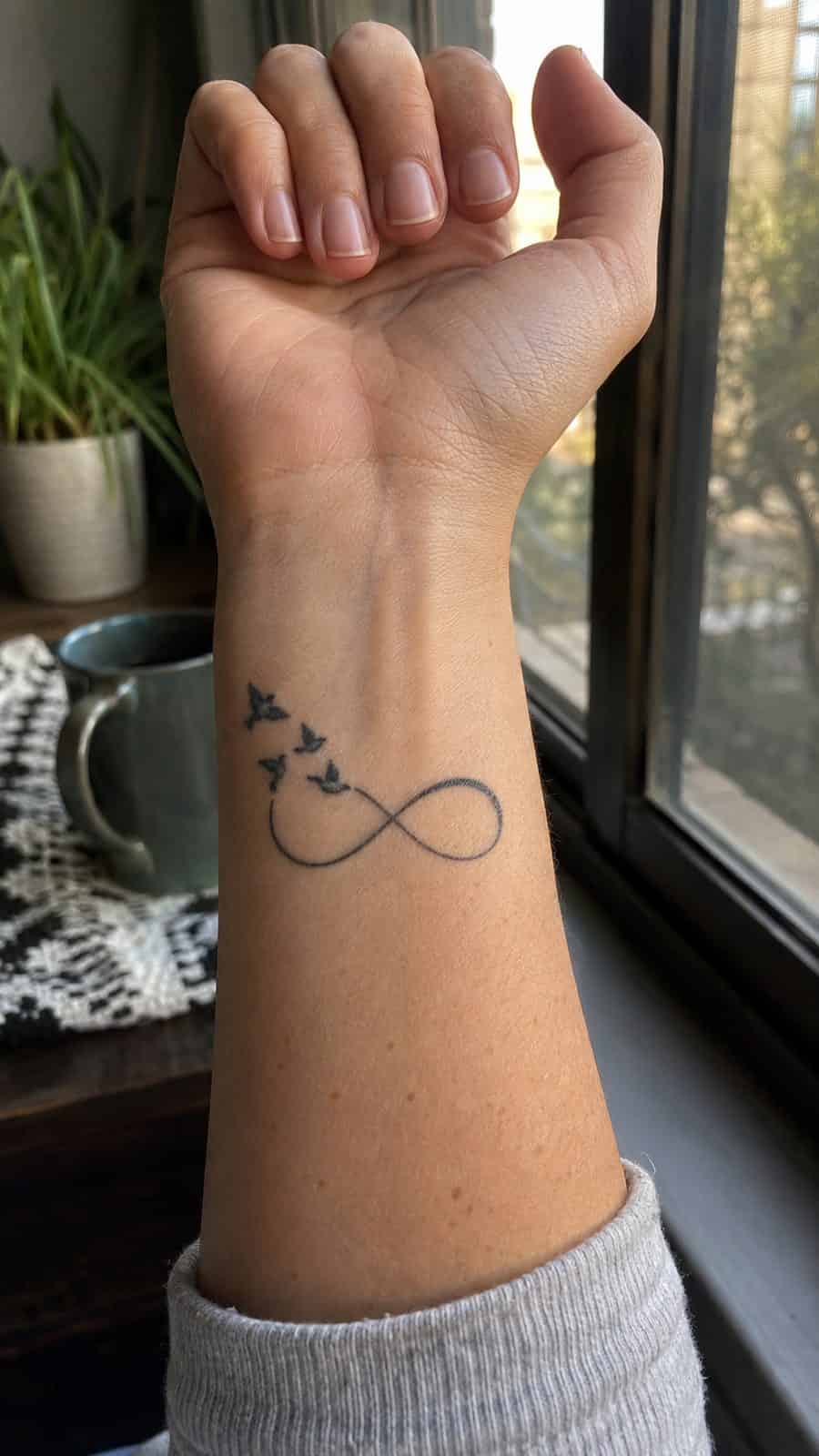 Wrist Tattoos Women Are Raving About: Discover the 28 Most Gorgeous Designs 7 Healed infinity symbol with birds tattoo on a adult woman's inner wrist, photographed in a natural straight-on close view, a touch — study 2