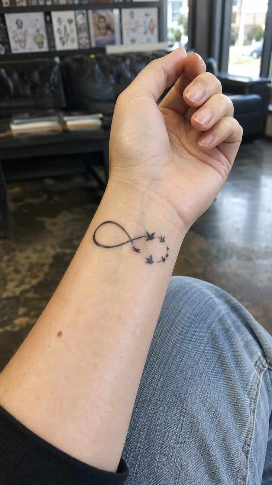 Wrist Tattoos Women Are Raving About: Discover the 28 Most Gorgeous Designs 8 Healed infinity symbol with birds tattoo on a adult woman's inner wrist, photographed in a natural gentle side angle that clearly — study 3
