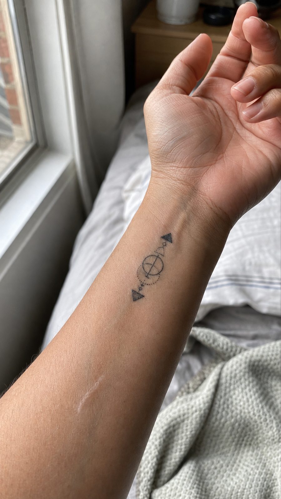 Wrist Tattoos Women Are Raving About: Discover the 28 Most Gorgeous Designs 15 Healed minimal geometric shapes tattoo on a adult woman's inner wrist, photographed in a natural gentle side angle that clearly shows — study 2