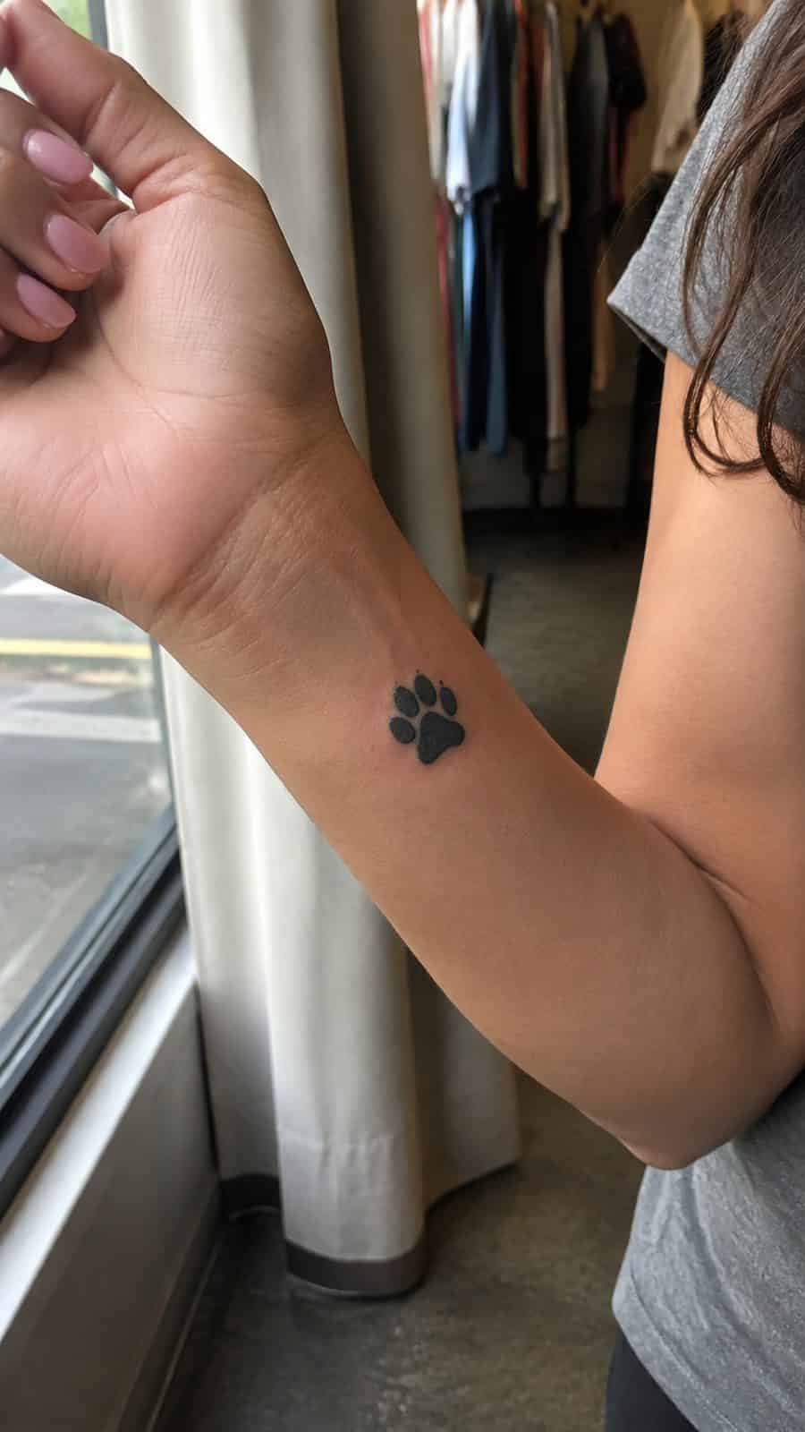 Wrist Tattoos Women Are Raving About: Discover the 28 Most Gorgeous Designs 26 Healed paw print tribute tattoo on a adult woman's inner wrist, photographed in a natural waist-height candid close-up — study 3