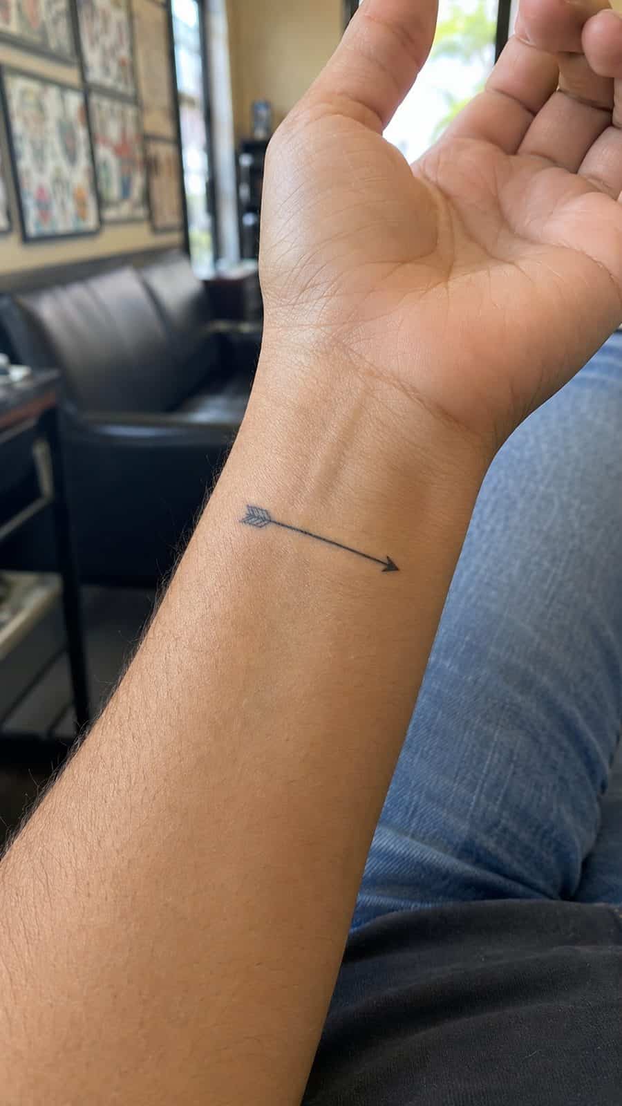 Wrist Tattoos Women Are Raving About: Discover the 28 Most Gorgeous Designs 29 Healed subtle arrow line tattoo on a adult woman's inner wrist, photographed in a natural slightly elevated close view — study 3