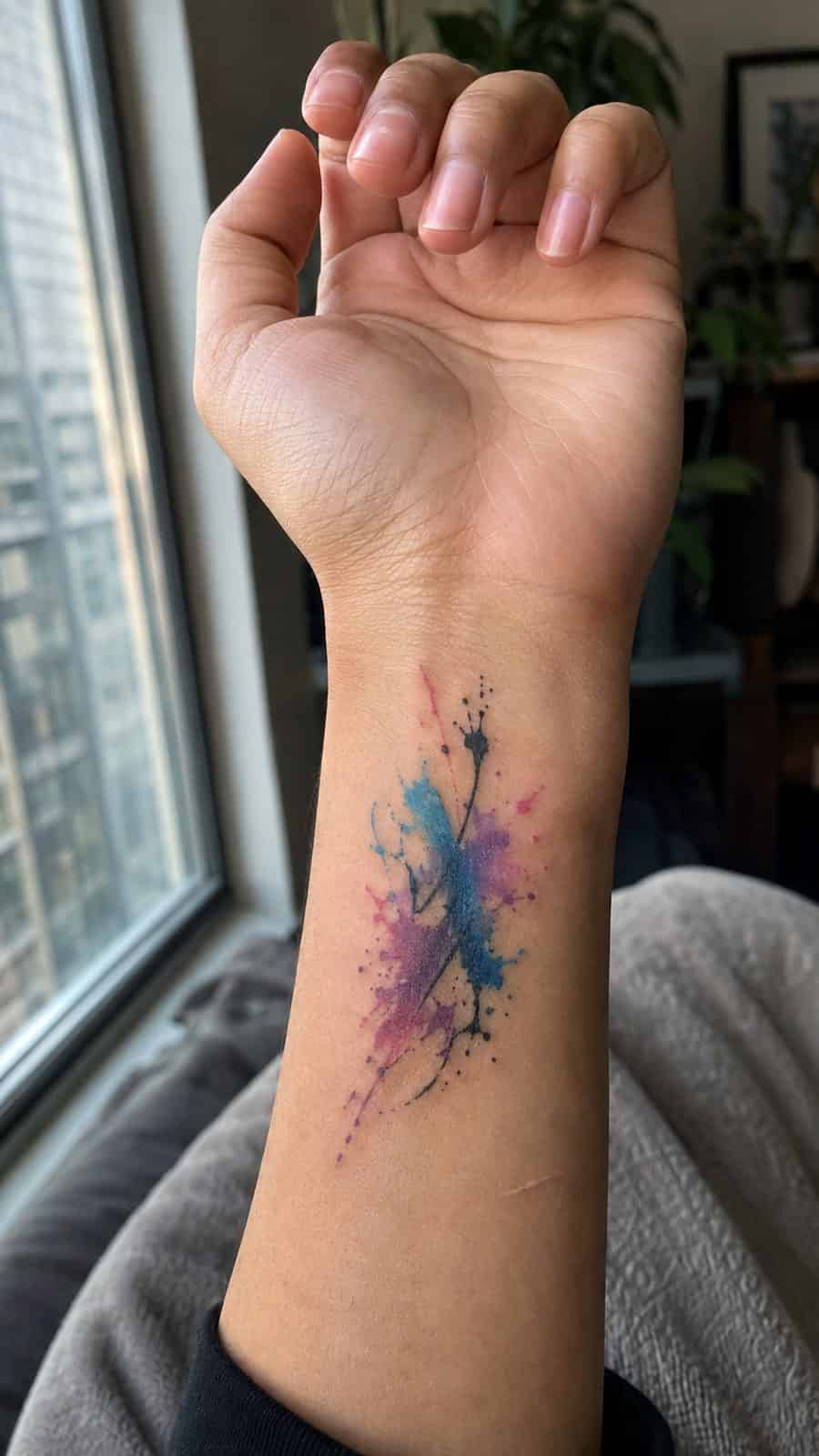 Wrist Tattoos Women Are Raving About: Discover the 28 Most Gorgeous Designs 35 Healed abstract watercolor splash tattoo on a adult woman's inner wrist, photographed in a natural casual close three-quarter view — study 1