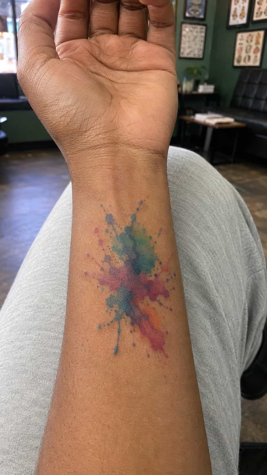 Wrist Tattoos Women Are Raving About: Discover the 28 Most Gorgeous Designs 36 Healed abstract watercolor splash tattoo on a adult woman's inner wrist, photographed in a natural straight-on close view, a touch — study 2