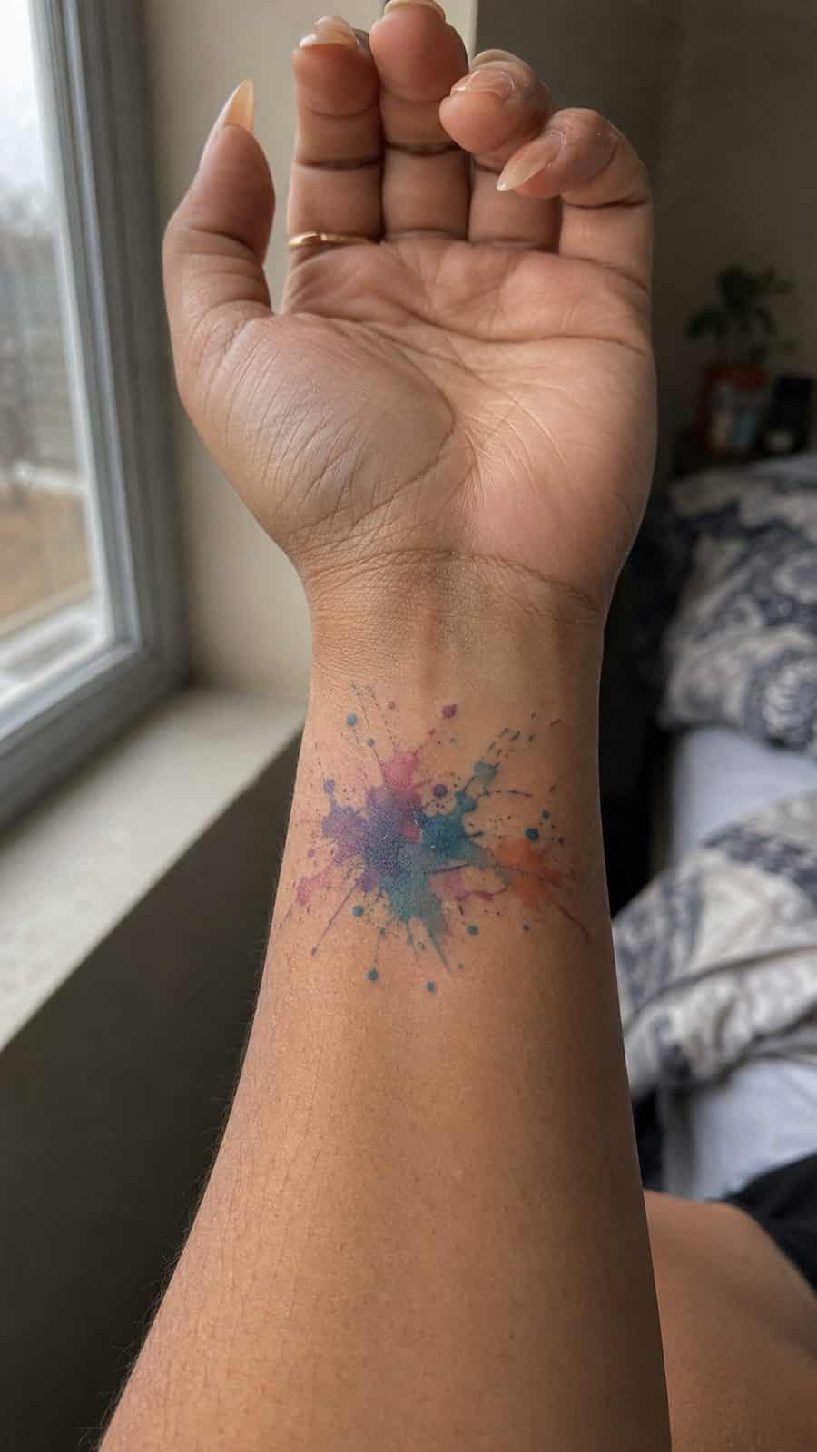 Wrist Tattoos Women Are Raving About: Discover the 28 Most Gorgeous Designs 37 Healed abstract watercolor splash tattoo on a adult woman's inner wrist, photographed in a natural gentle side angle that clearly — study 3