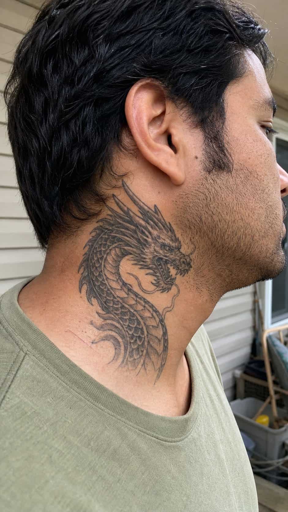15 Neck Tattoo Ideas for Men Worth Considering 13 Healed mythical dragon tattoo on a adult man's side neck, photographed in a natural slightly elevated close view — study 1