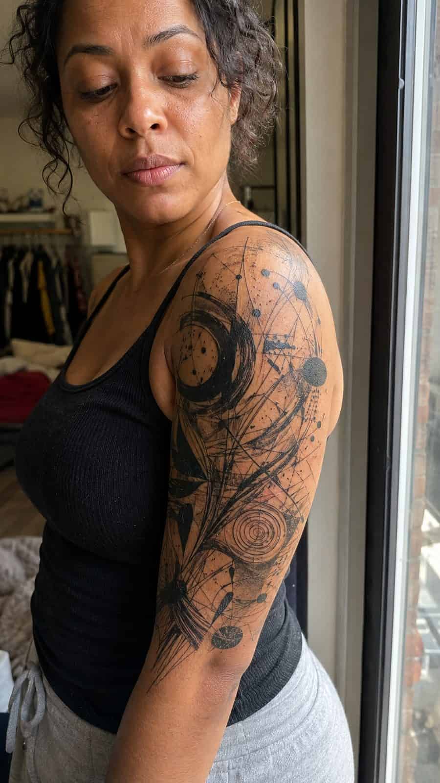20 Edgy Grunge Tattoo Ideas for Women Who Break the Rules 4 Healed abstract chaos sleeve tattoo on a adult woman's upper-arm sleeve, photographed in a natural casual close three-quarter view — study 1