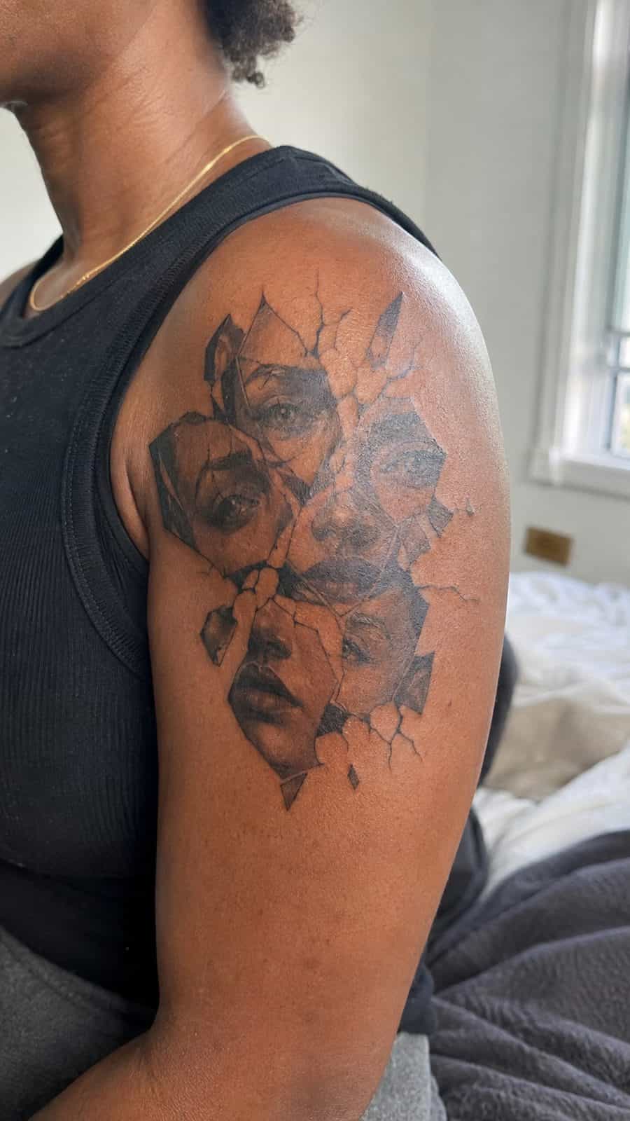 Healed broken mirror reflection tattoo on a adult person's shoulder, photographed in a natural slightly elevated close view — study 2