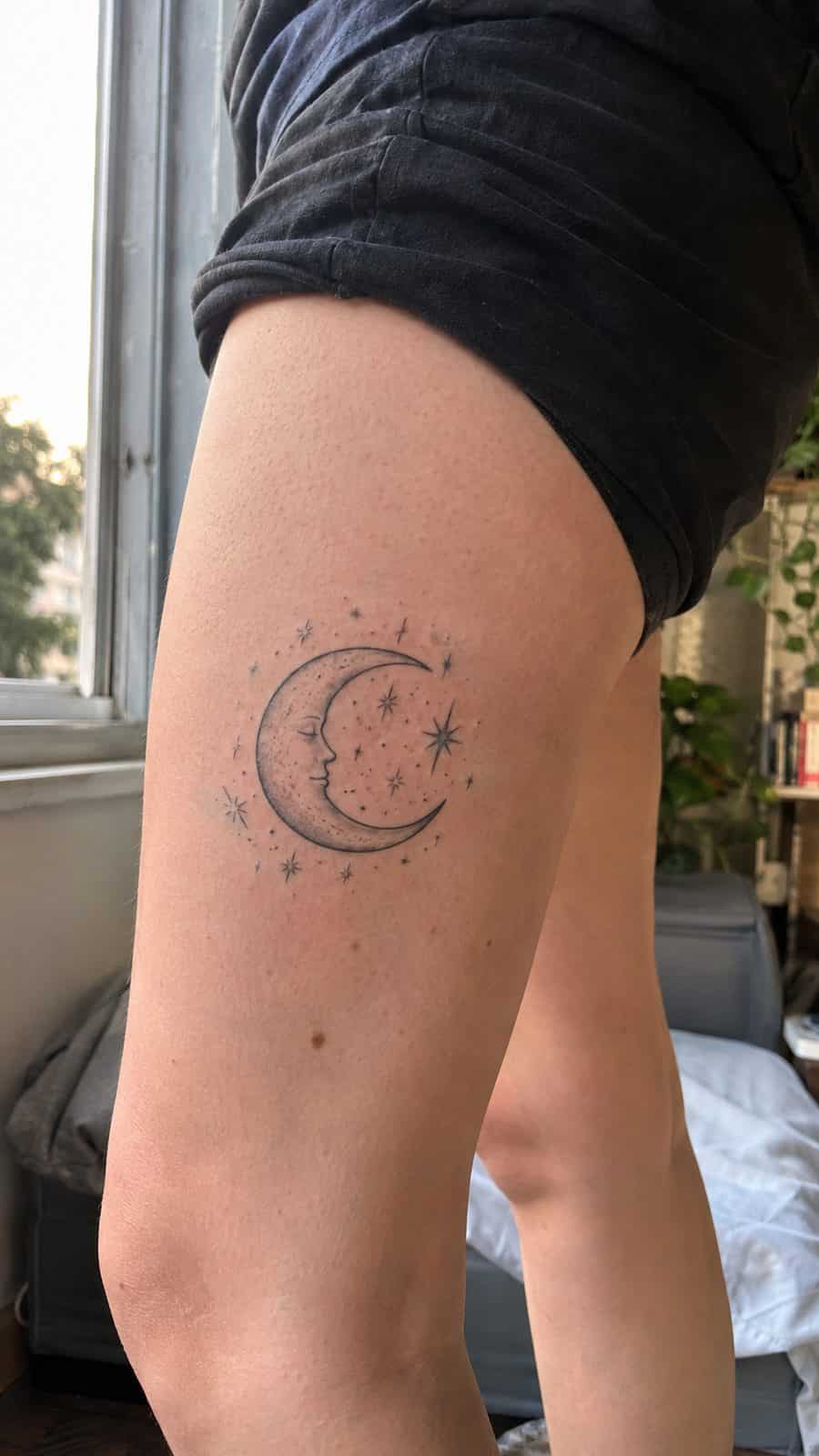 Healed crescent moon and stars tattoo on a adult person's outer thigh, photographed in a natural gentle side angle that clearly shows — study 1