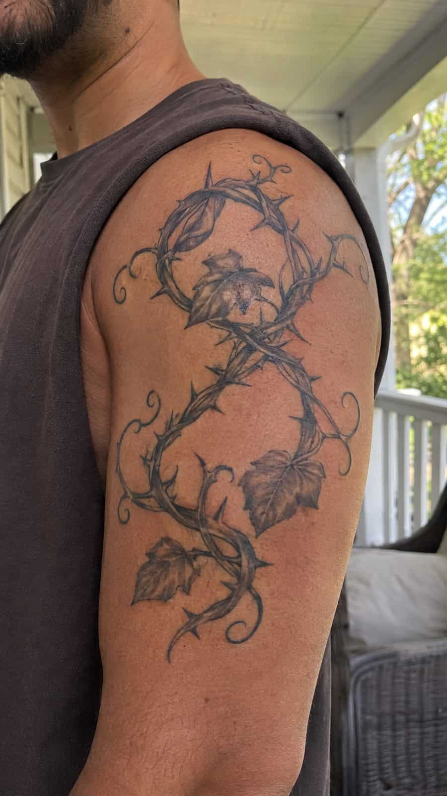 Healed vine and thorns tattoo on a adult person's shoulder, photographed in a natural slightly elevated close view — study 1