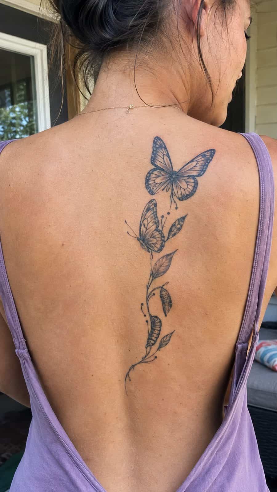 Healed butterfly in transition tattoo on a adult person's upper back, photographed in a natural straight-on close view, a touch — study 2