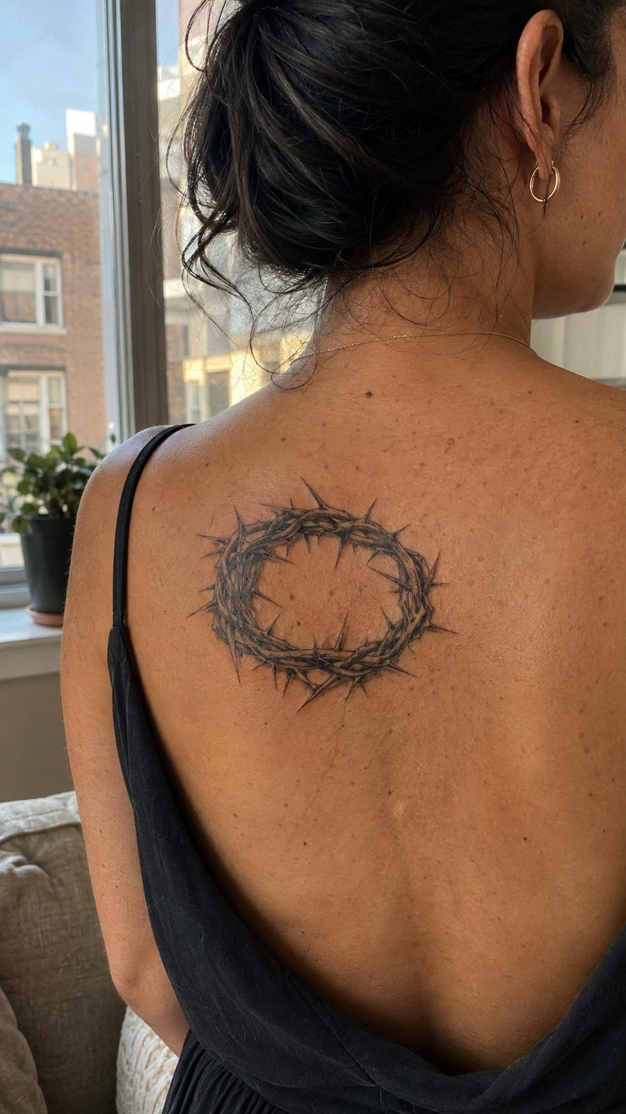 Healed crown of thorns tattoo on a adult person's upper back, photographed in a natural slightly elevated close view — study 3
