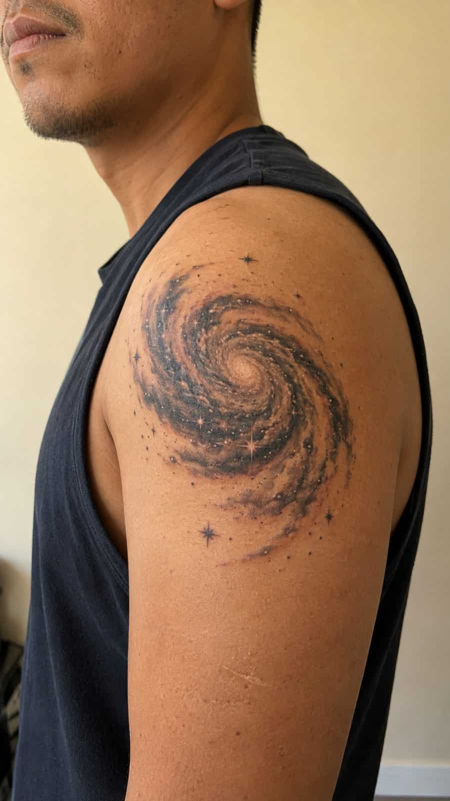 Healed spiral galaxy tattoo on a adult person's shoulder, photographed in a natural gentle side angle that clearly shows how the ink — study 2
