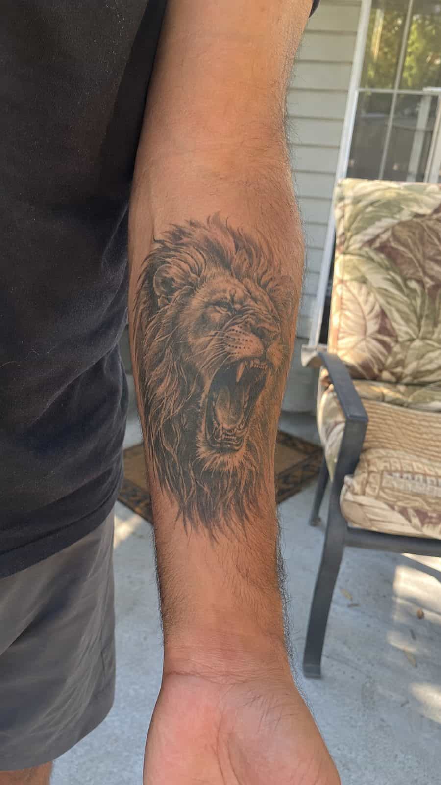 Unleash Your Inner Strength: 20 Male Lion Tattoo Ideas You Need to See 2 Healed regal roar tattoo on a adult man's inner forearm, photographed in a natural relaxed documentary crop — study 1