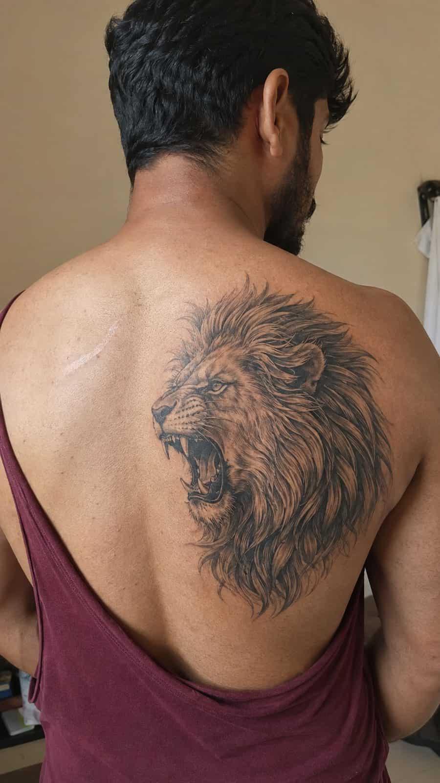 Unleash Your Inner Strength: 20 Male Lion Tattoo Ideas You Need to See 3 Healed regal roar tattoo on a adult man's upper back, photographed in a natural casual close three-quarter view — study 2