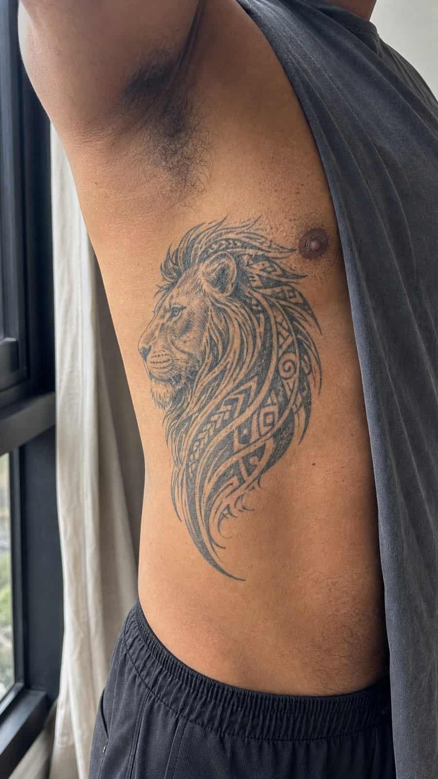 Unleash Your Inner Strength: 20 Male Lion Tattoo Ideas You Need to See 25 Healed tribal majesty tattoo on a adult man's side ribs, photographed in a natural casual close three-quarter view — study 1
