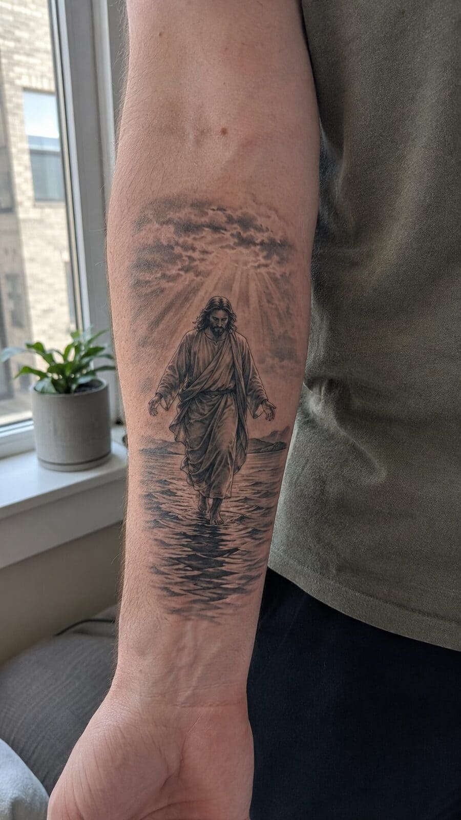 Exploring 18 Profound Jesus Tattoo Ideas for the Modern Man 8 Healed jesus walking on water tattoo on a adult man's inner forearm, photographed in a natural relaxed documentary crop — study 3