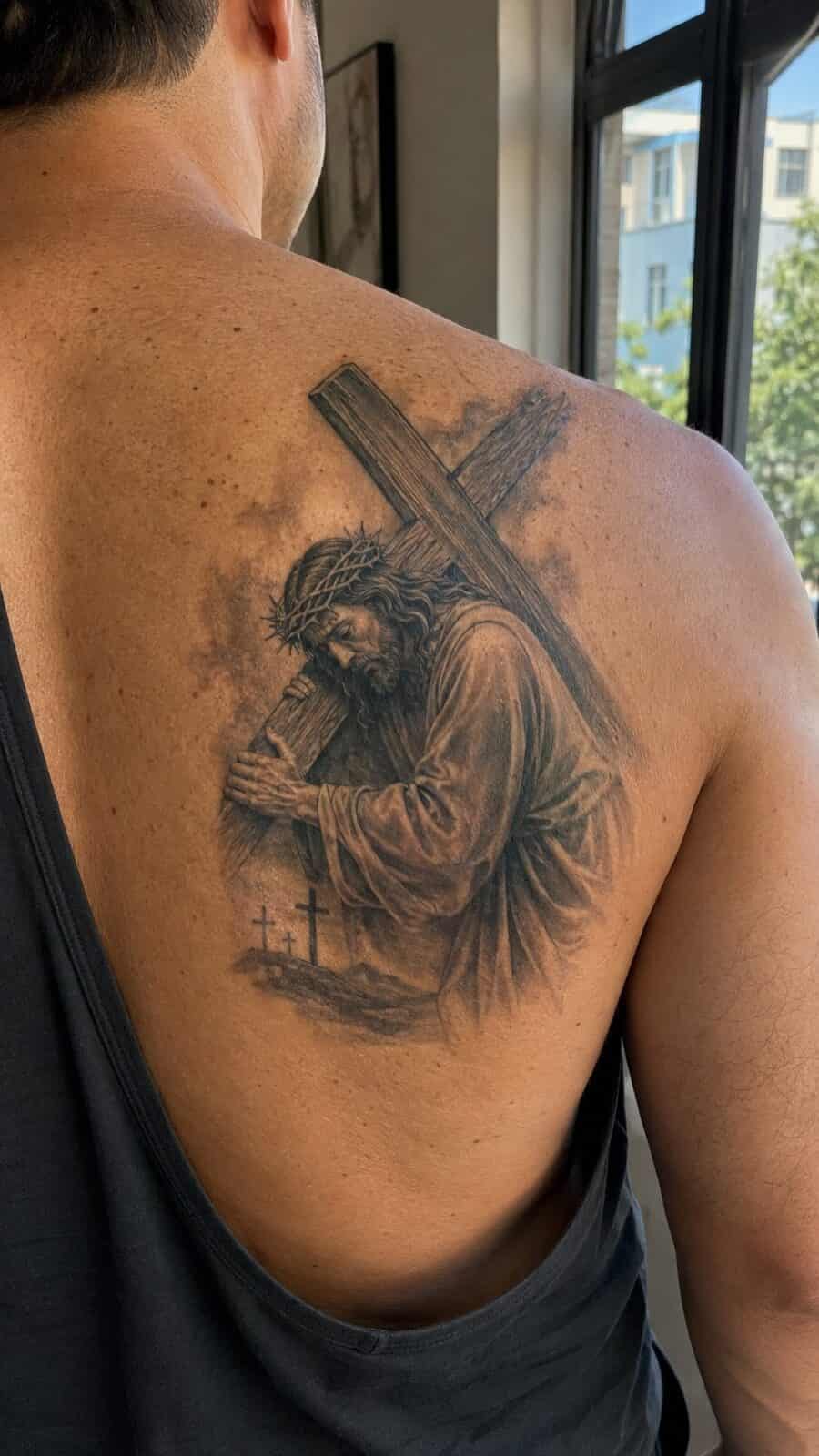 Exploring 18 Profound Jesus Tattoo Ideas for the Modern Man 14 Healed jesus with the cross tattoo on a adult man's upper back, photographed in a natural straight-on close view, a touch off-center — study 2