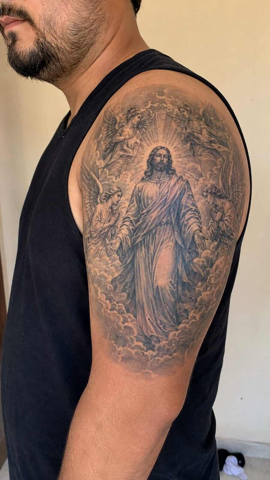 Exploring 18 Profound Jesus Tattoo Ideas for the Modern Man 17 Healed jesus with angels tattoo on a adult man's shoulder, photographed in a natural gentle side angle that clearly shows how the ink — study 2