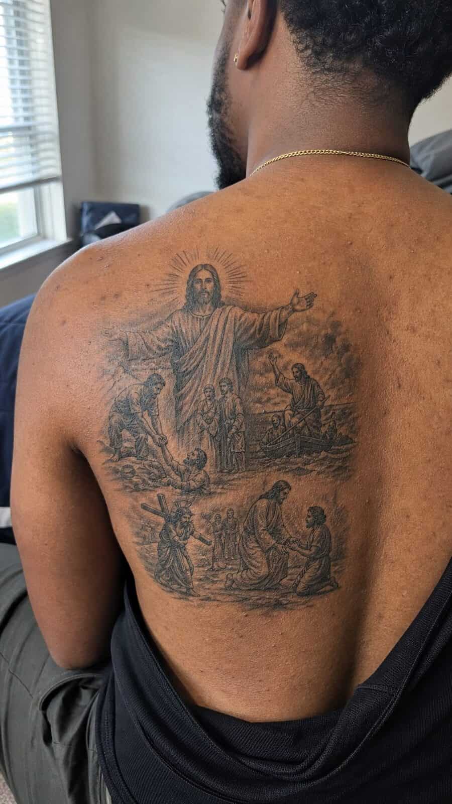 Exploring 18 Profound Jesus Tattoo Ideas for the Modern Man 42 Healed jesus and the miracles tattoo on a adult man's upper back, photographed in a natural casual close three-quarter view — study 3