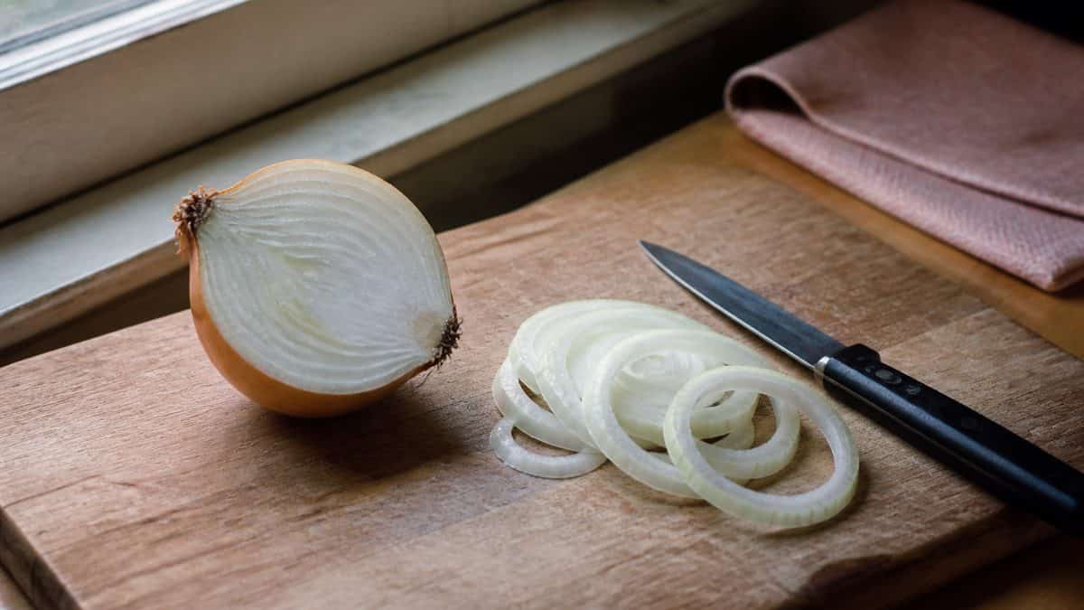 Home Remedies Every '60s Mom Swore By 8 Person slicing a raw onion