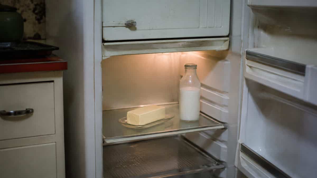 Home Remedies Every '60s Mom Swore By 10 Person taking a standard stick of butter from a refrigerator