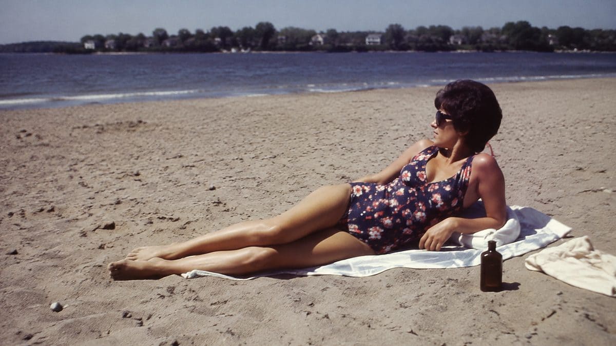Genuine 1970s photo of woman sunbathing with baby oil