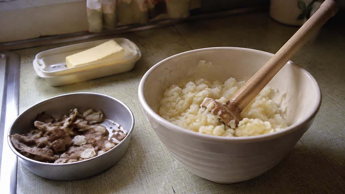 12 Comfort Foods That Taste Better Made the Old-Fashioned Way 4 Someone mashing potatoes